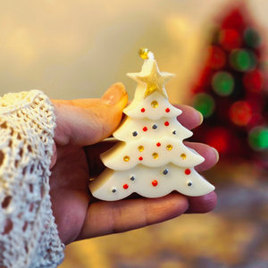 Kerst cadeauset met witte figuurkaarsen: rendier, kerstboom en gingerbread in gouden doos met rood lint en gouden belletjes